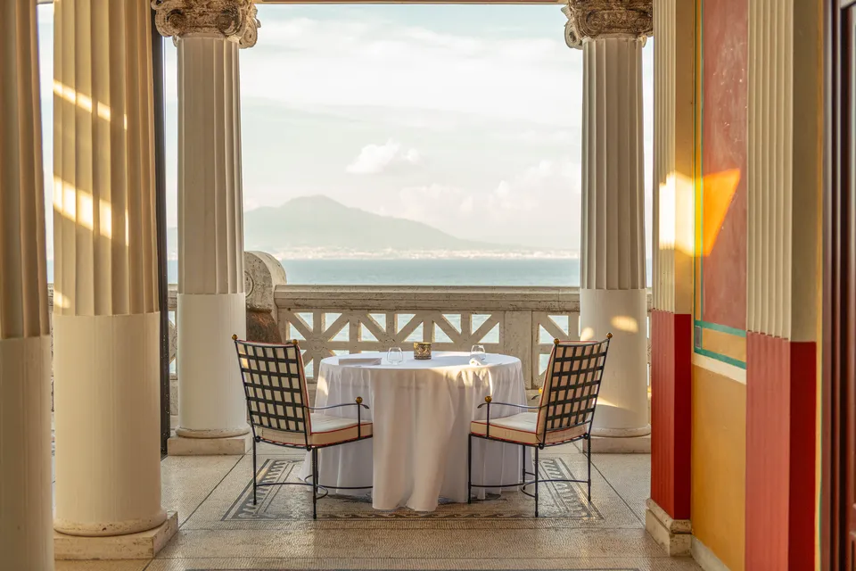 Bellevue Syrene — Un tavolo tra le colonne, di fronte al Vesuvio