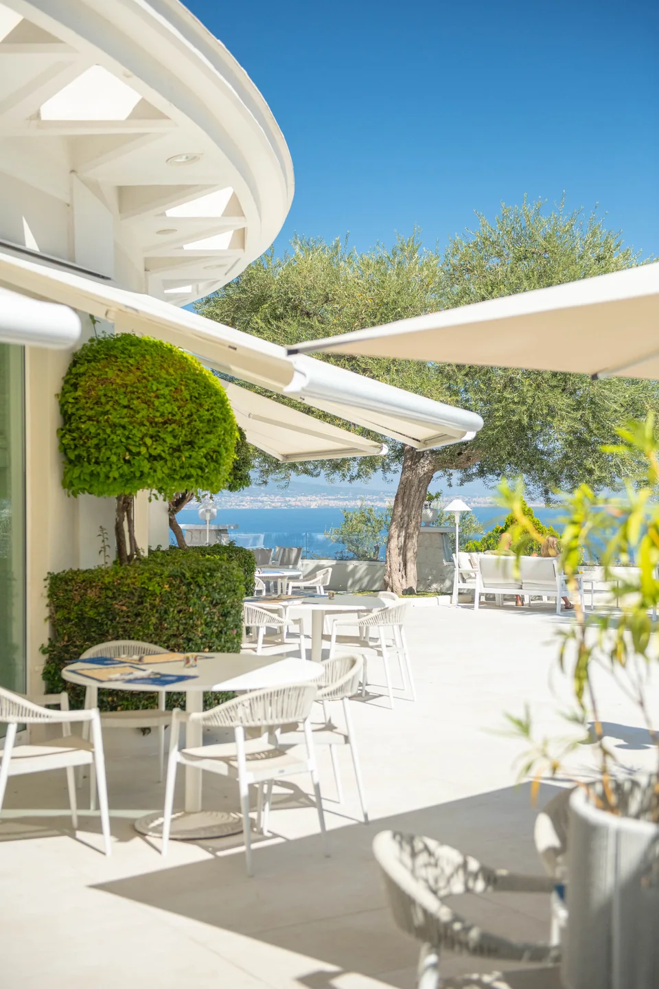 Il giardino del Grand Hotel Aminta tra arredi bianchi e cielo azzurro