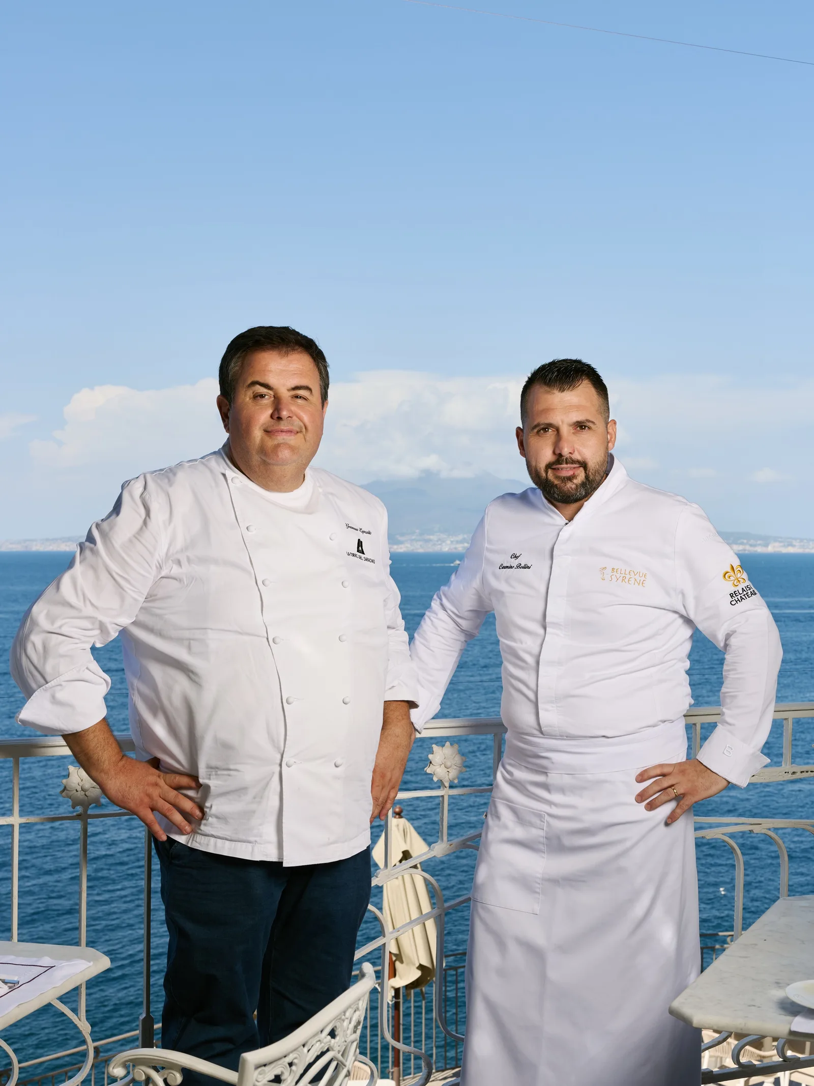 Due chef in giacca bianca davanti al mare