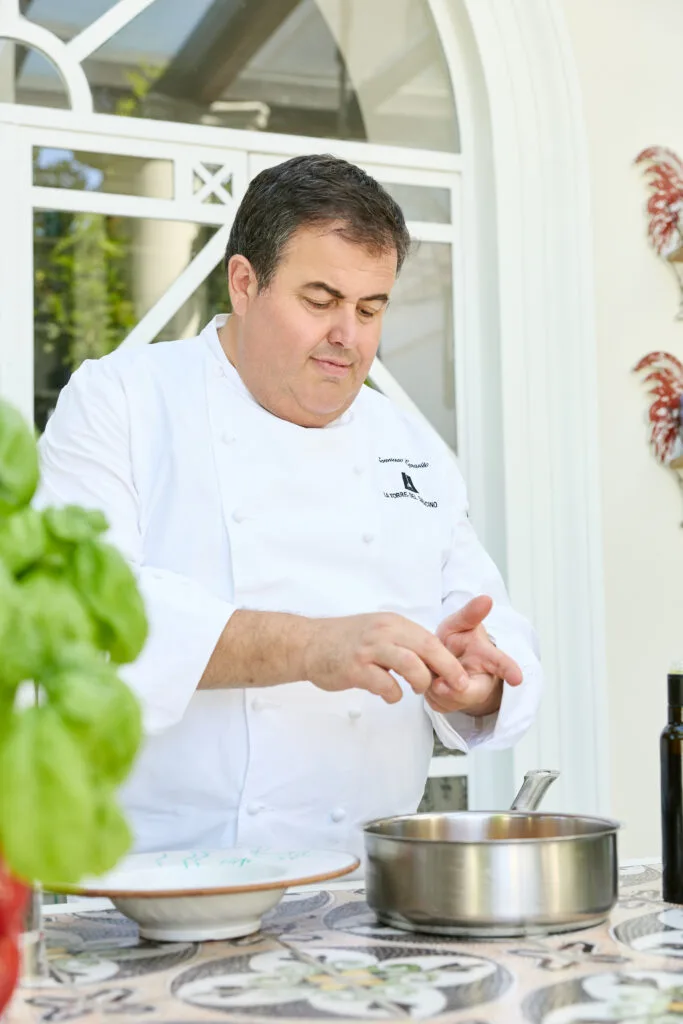Chef in giacca bianca mentre prepara un piatto